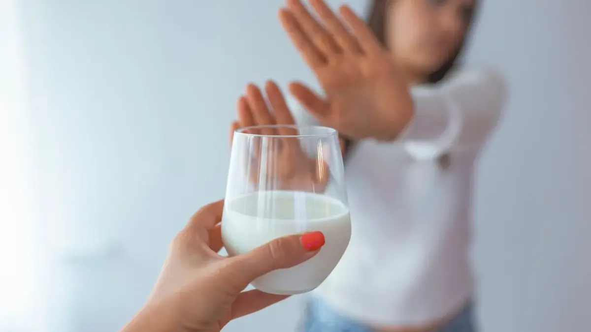 Kobieta, która ma nietolerancję laktozy, odmawia wypicia mleka.