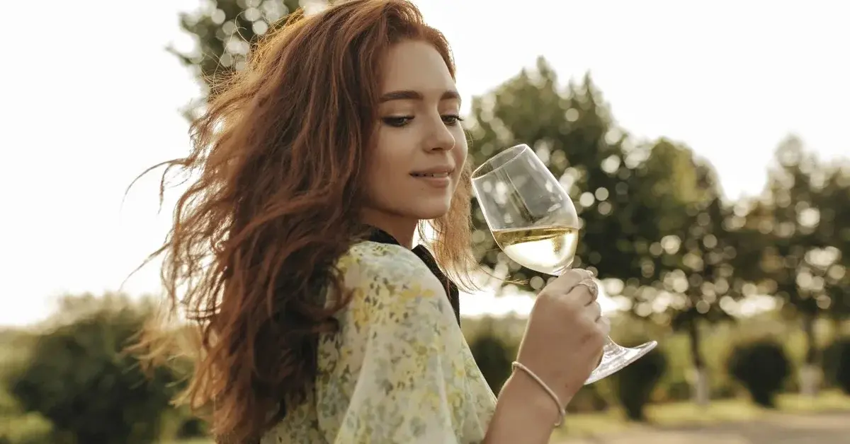 Kobieta smakująca białe wino ze sklepu lebarbatelle