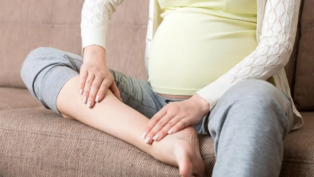 Kobieta w ciąży ma spuchnięte kostki od zatrzymania wody w organizmie.