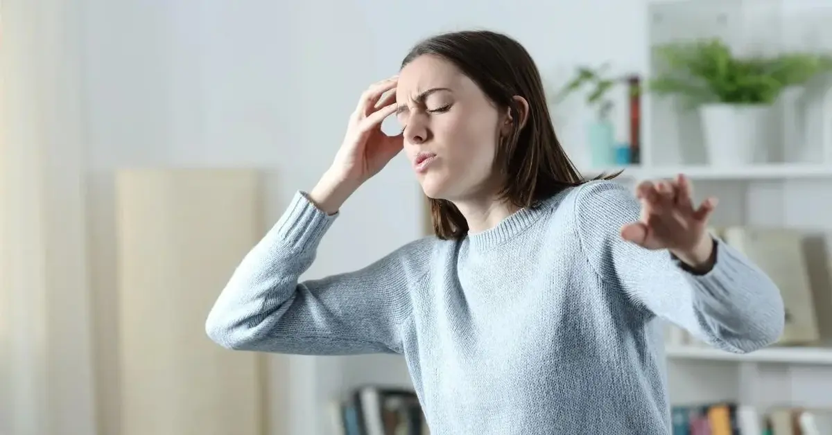 Kobieta z powodu wysokiego ciśnienia ma zawroty głowy.