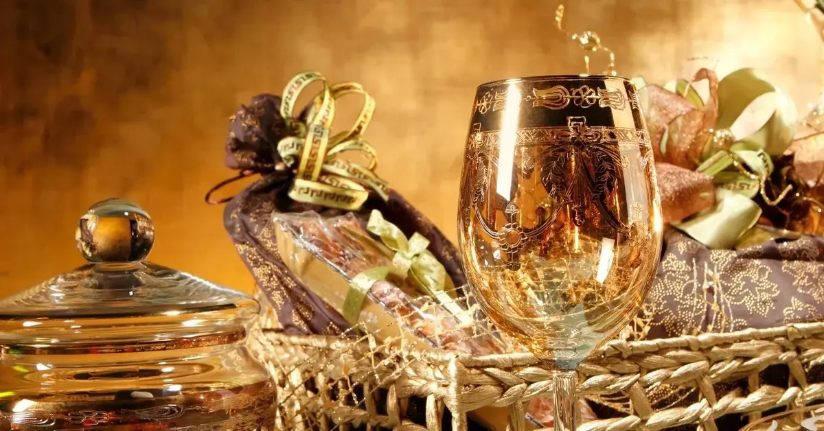 Kosz z pięknie opakowanymi słodyczami i kieliszkiem, jako prezent na ślub.