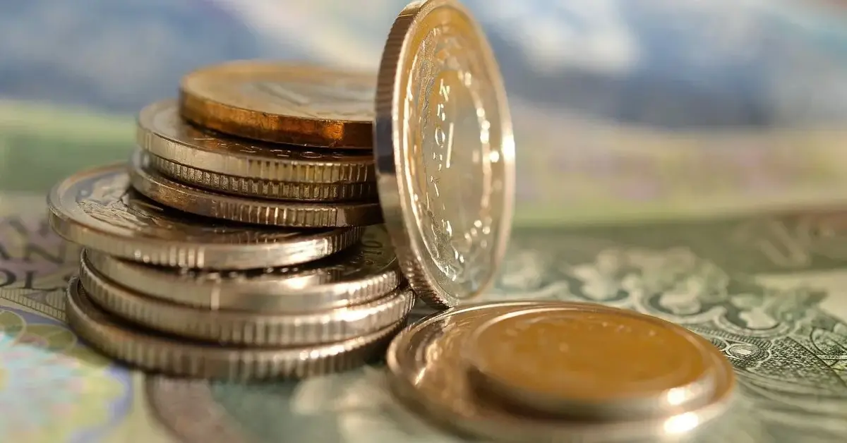 Słupek złotych monet ułożony na banknocie