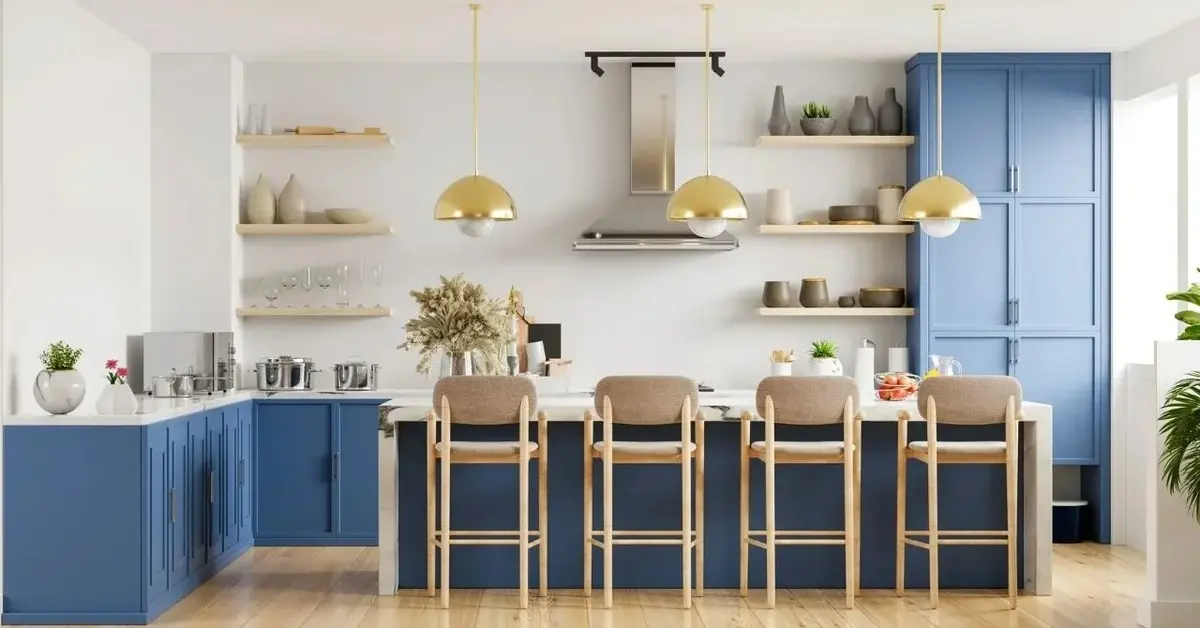 Kuchnia z niebieskimi szafkami i złotymi lampami wiszącymi nad wyspą kuchenną