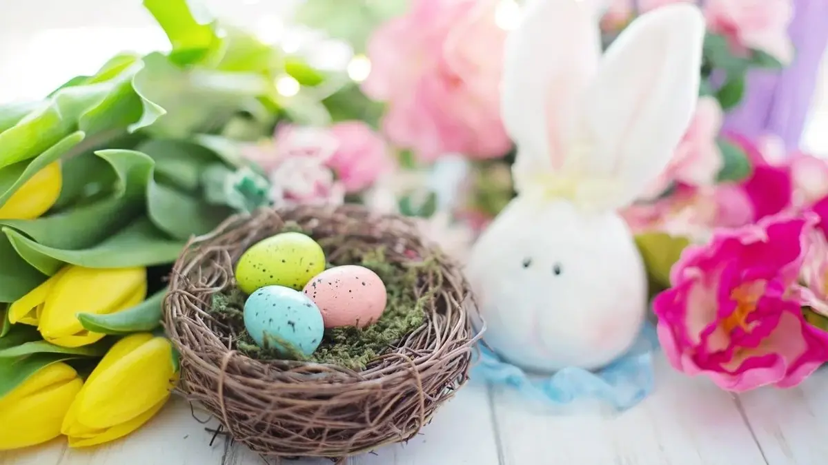 Wielkanocne dekoracje - żółte tulipany, pisanki w gniazdku i biały królik