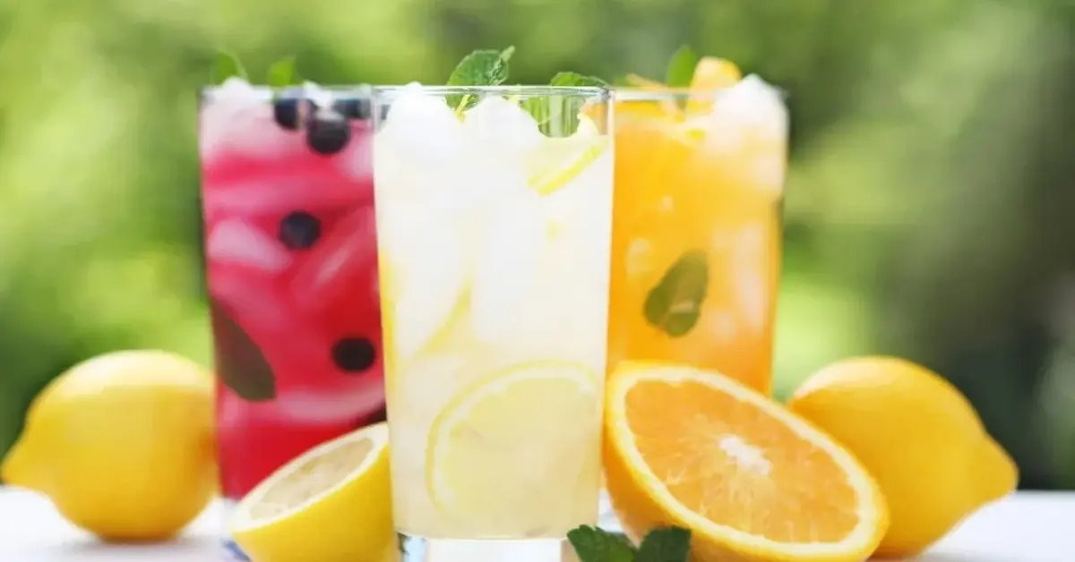 kolorowe lemoniady w szklankach obok owoce
