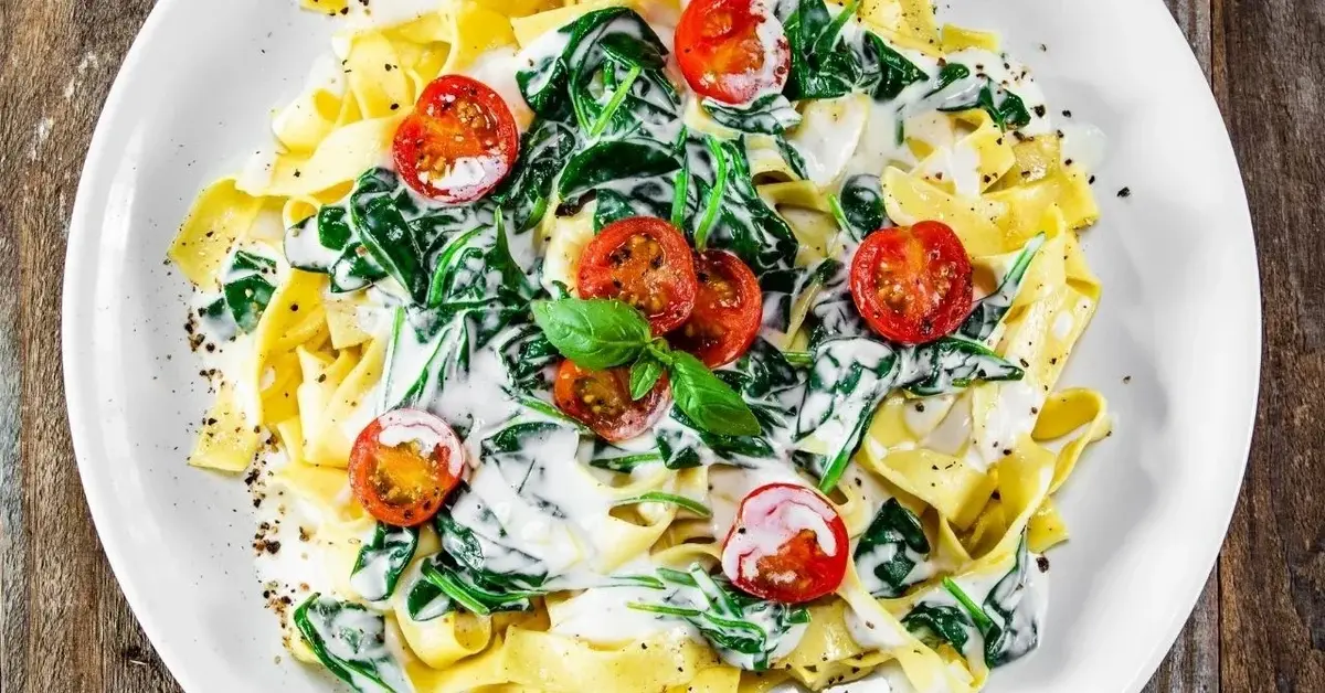 Makaron tagliatelle z sosem z sera gorgonzola ze szpinakiem i pomidorkami koktajlowymi