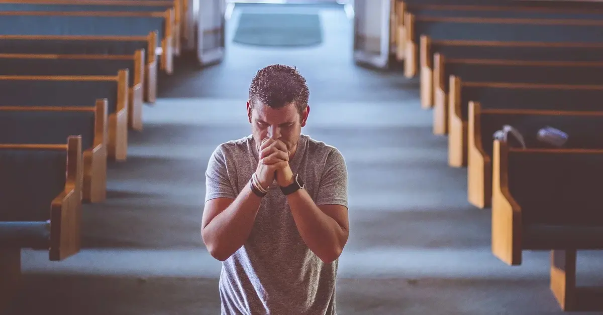 mężczyzna modlący się w kościele 