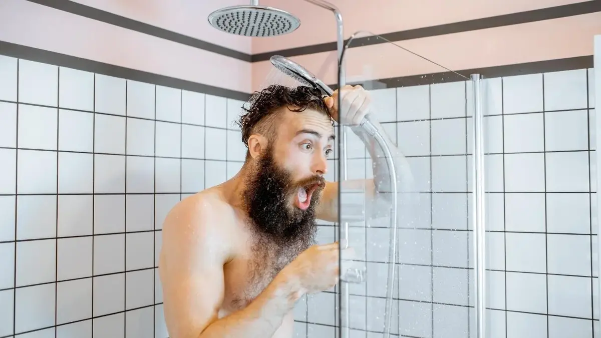 Mężczyzna bierze zimny prysznic, żeby obudzić się rano.