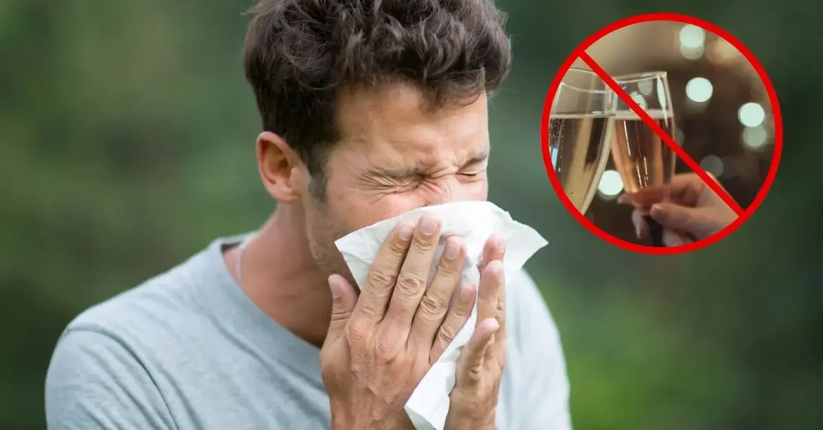 Mężczyzna kicha, po tym, jak pił alkohol.