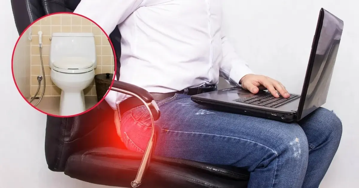 Mężczyzna siedzący na krześle ma hemoroidy. Widać toaletę.