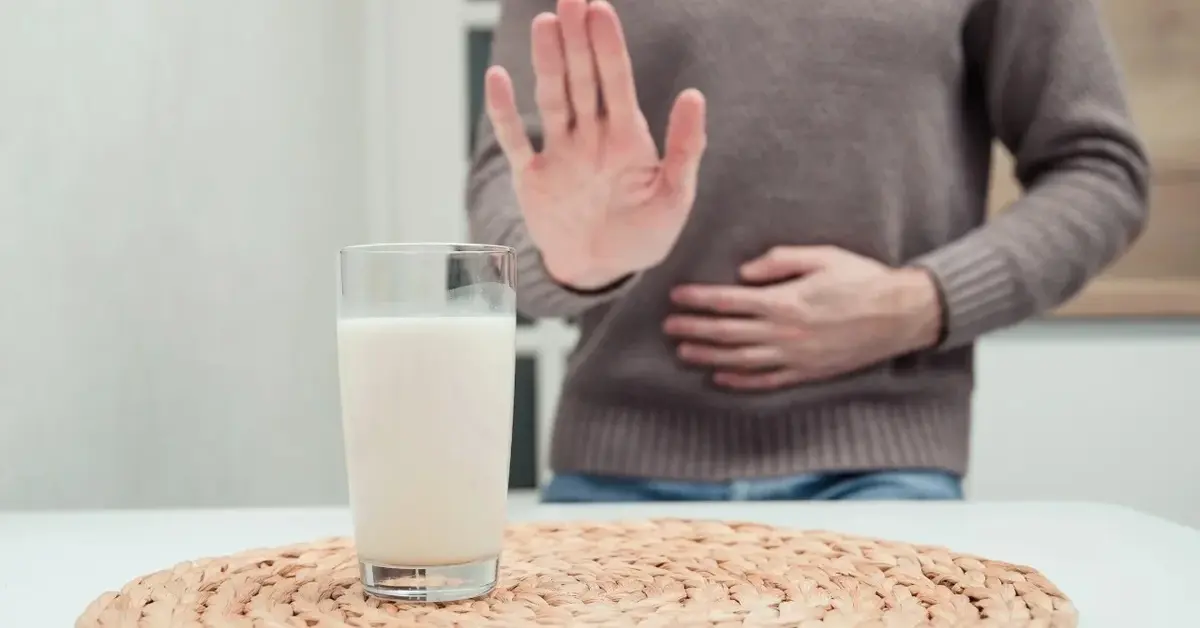 Mężczyzna, który ma nietolerancję laktozy odmawia wypicia mleka ze szklanki.