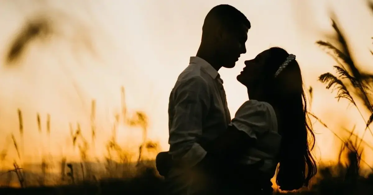 Mężczyzna spod znaku Skorpiona razem z ukochaną kobietą na tle zachodzącego słońca.