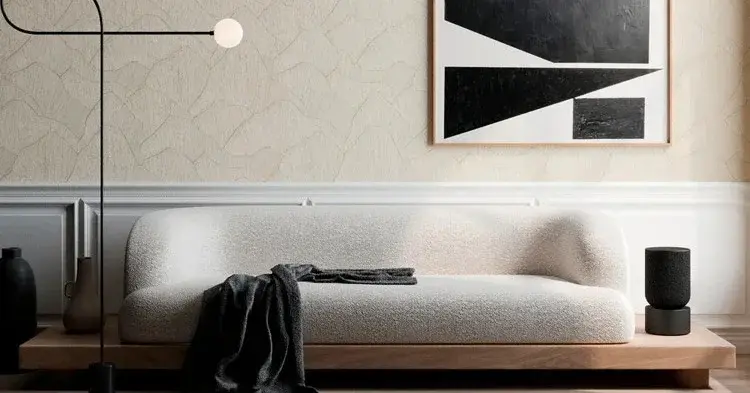 Minimalistyczne wnętrze z tapetą ścienną oraz jasną sofą i dezajnerską lampą