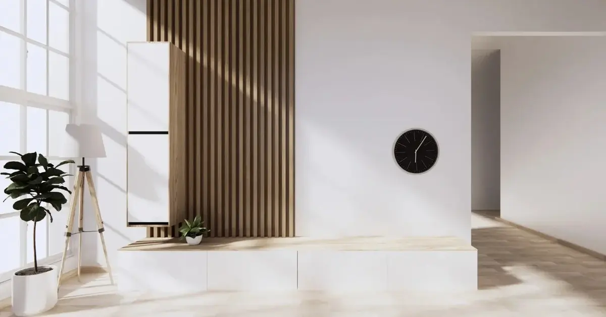 minimalistyczny salon białe ściany lamele drewniane czarny zegar kwiatek proste szafki