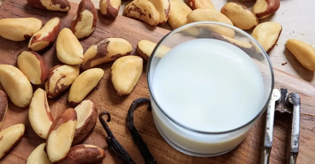 orzechy brazylijskie i gotowe mleko orzechowe na drewnianej desce