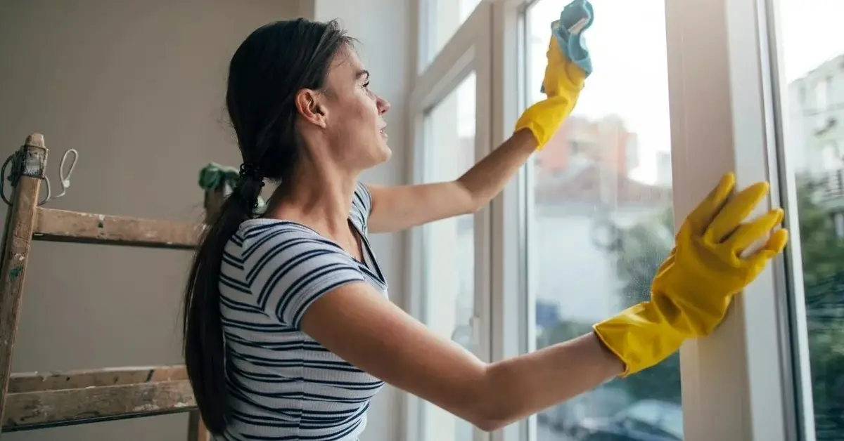 Kobieta myje okna tak, żeby nie było smug.