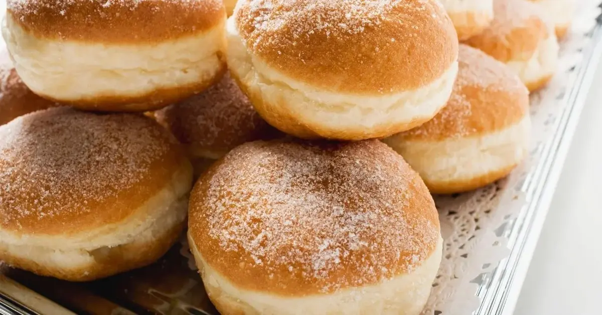 Taca z dużą ilością pączków posypanych cukrem pudrem