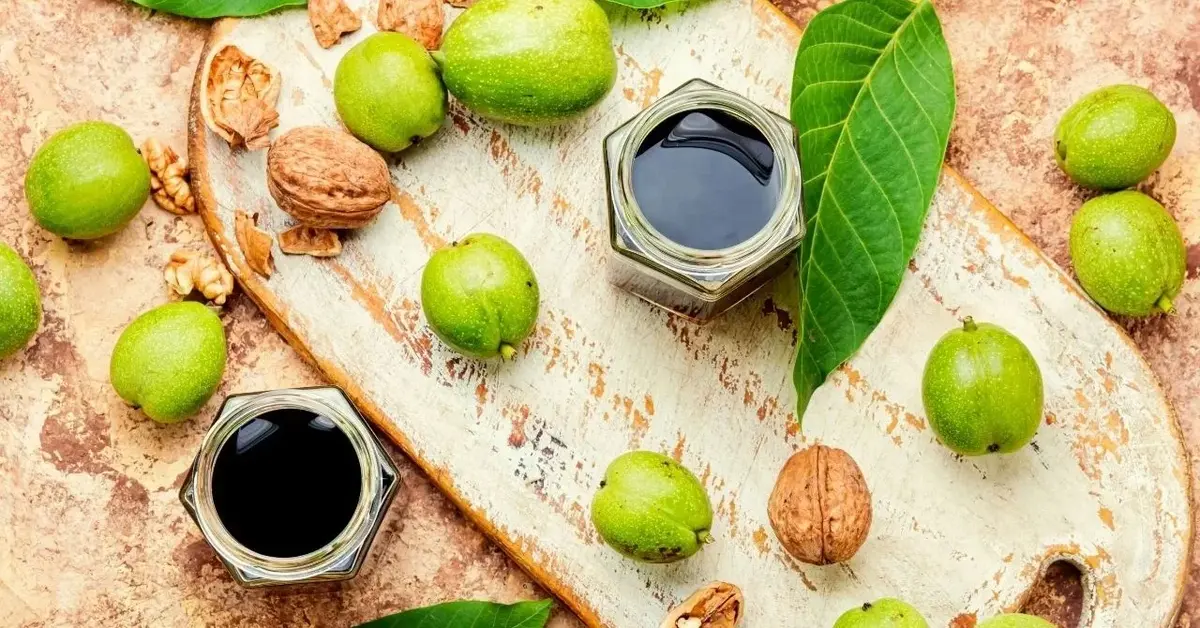 nalewka z zielonych orzechów w słoiczkach i zielone orzechy na desce