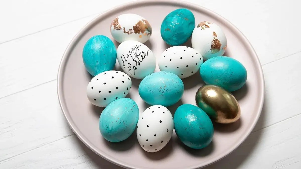 Pomalowane jajka wielkanocne: niebieskie, złote, białe w kropki.