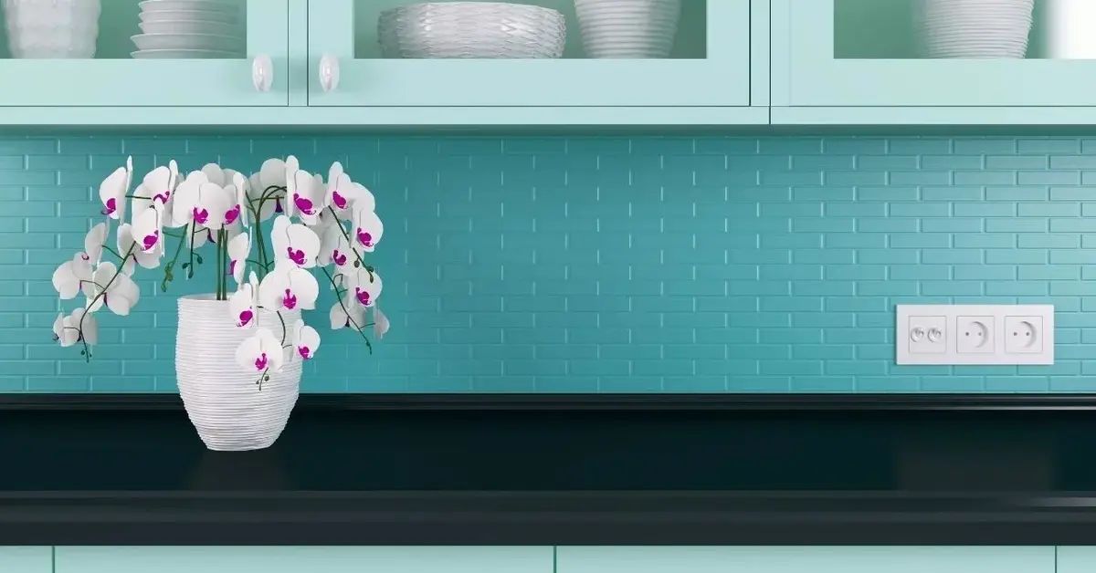 Niebieskie płytki-cegiełki tworzące backsplash nad blatem w kuchni