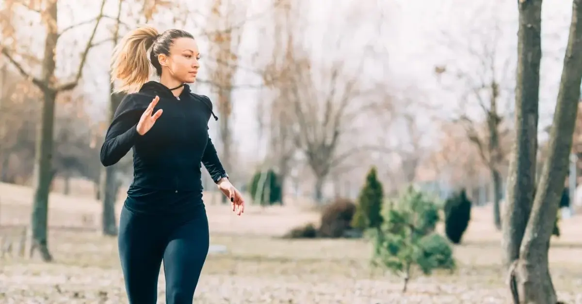 Kobieta blond kucyk w odzieży do biegania w zimie w czasie joggingu w parku