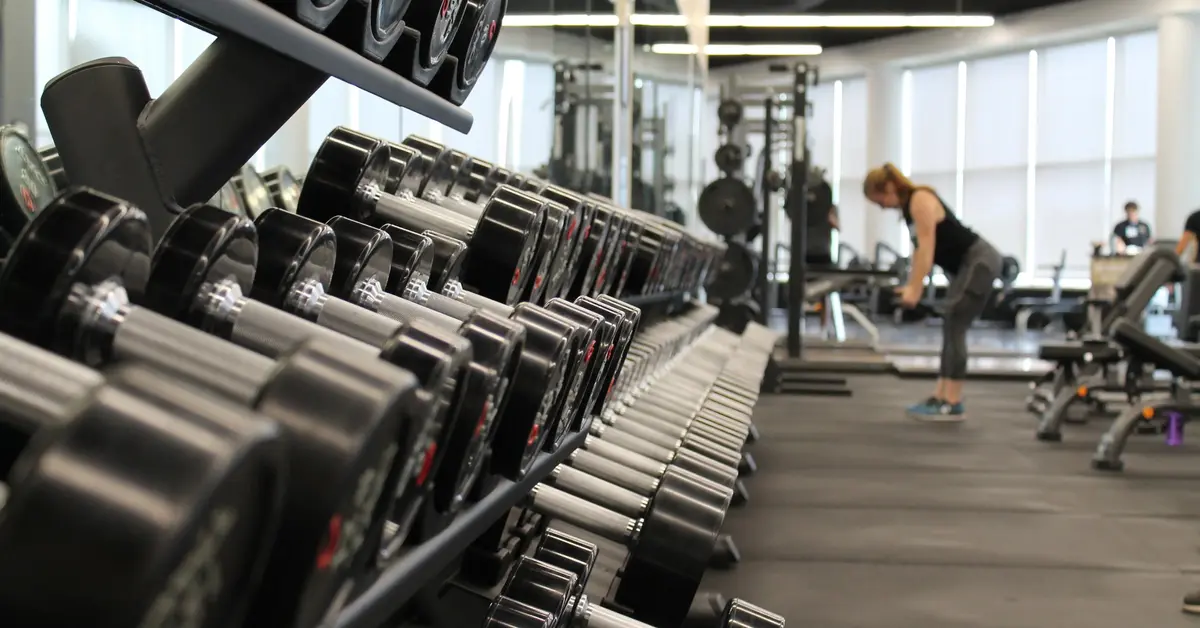 Widok na salę na siłowni ze sprzętem do ćwiczeń przy których pomagają odżywki białkowe