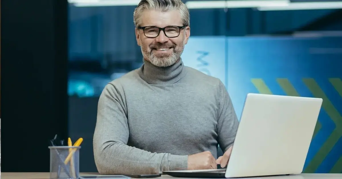 Mężczyzna w okularach pracuje przy laptopie