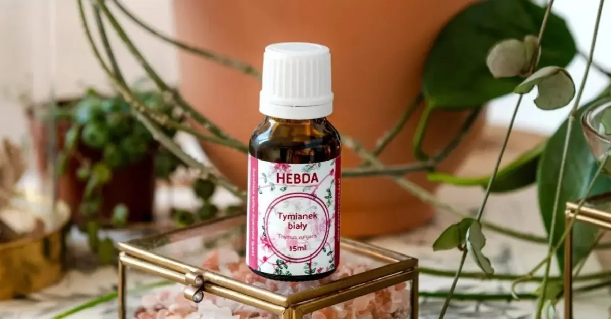 Buteleczka z olejkiem na przeziębienie tymiankowym na ładnej szkatułce w otoczeniu kwiatów doniczkowych