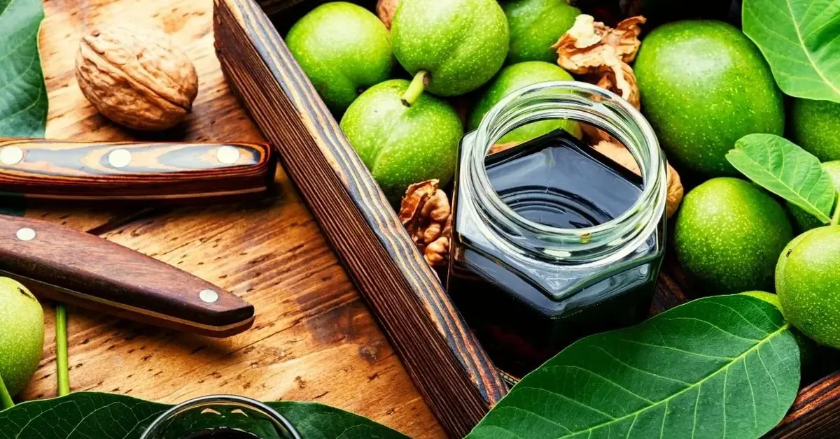 nalewka z orzechów włoskich w słoiku oraz orzechy włoskie na drewnianej tacy