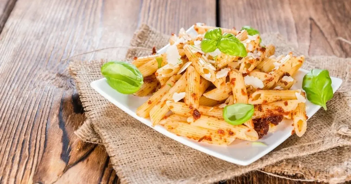 makaron penne z orzechowym pesto na białym talerzu