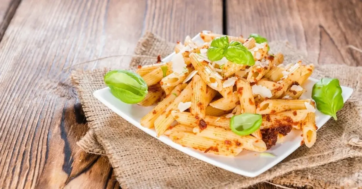 makaron penne z orzechowym pesto na białym talerzu