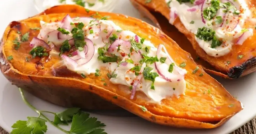 Pieczone bataty z gzikiem ziołowym podane na białym talerzu