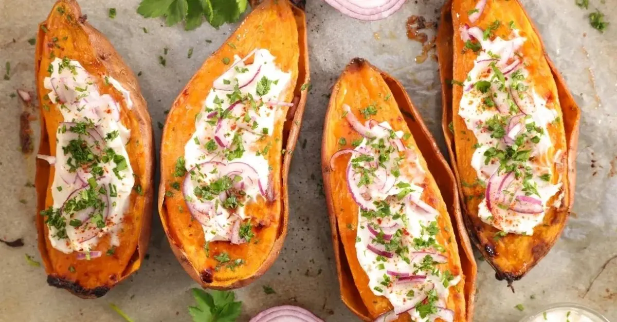 Pieczone bataty z dodatkiem gziku ziołowego, udekorowane szczypiorkiem i czerwoną cebulą