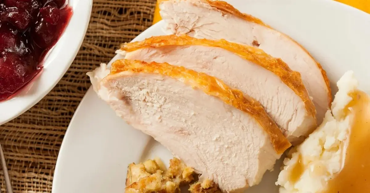 Indyk w pomarańczach i miodzie pokrojony na talerzu.