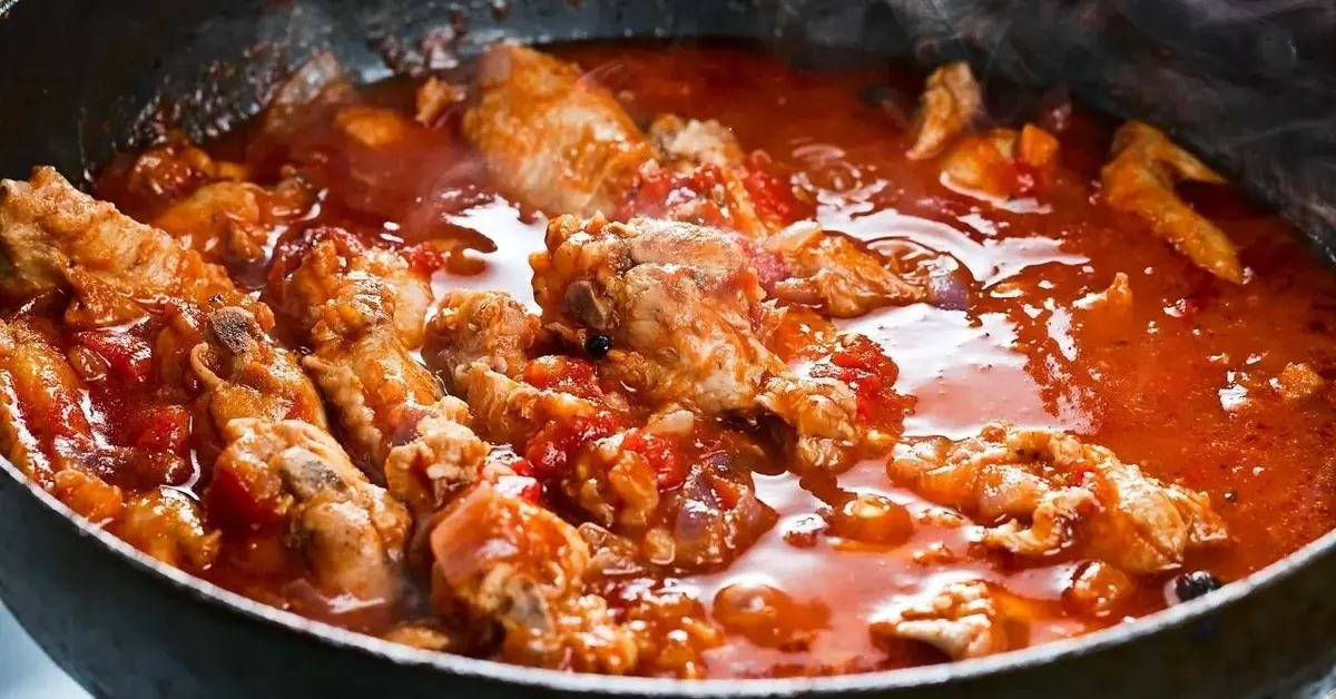 Pierś kurczaka duszona w sosie pomidorowym.