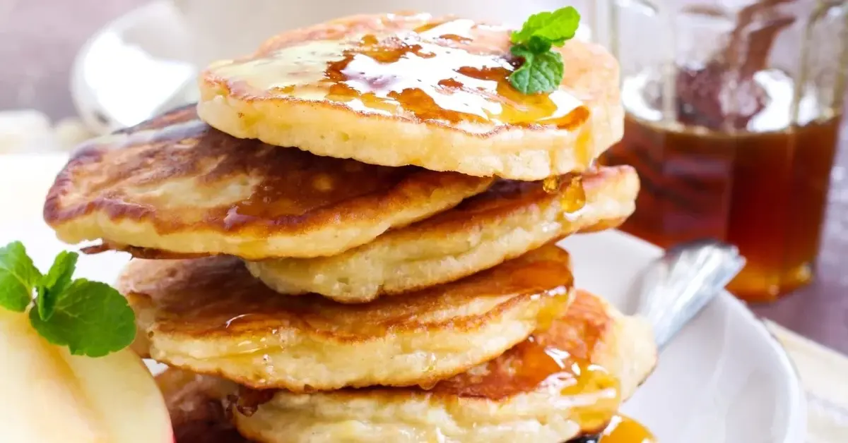 Placki z jabłkiem i jogurtem ułożone jedne na drugi.