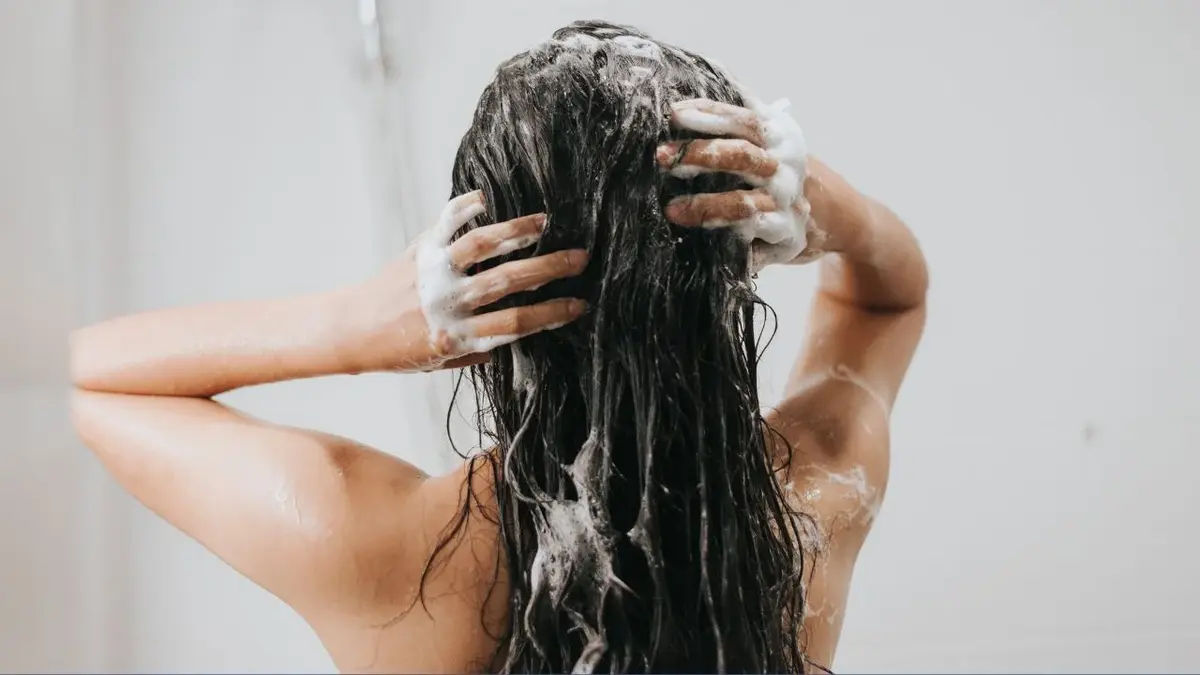 Kobieta pod prysznicem myje włosy
