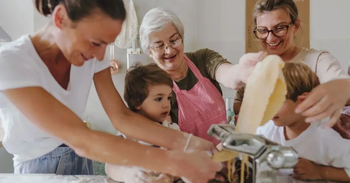 Rodzina wraz z babcią gotują radośnie w kuchni według przepisu babci