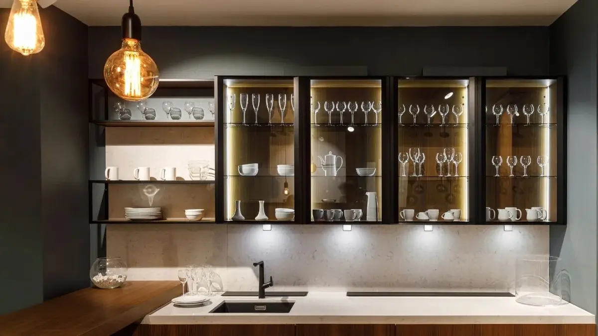 Przeszklone szafki wiszące w nowoczesnej czarno-białej kuchni