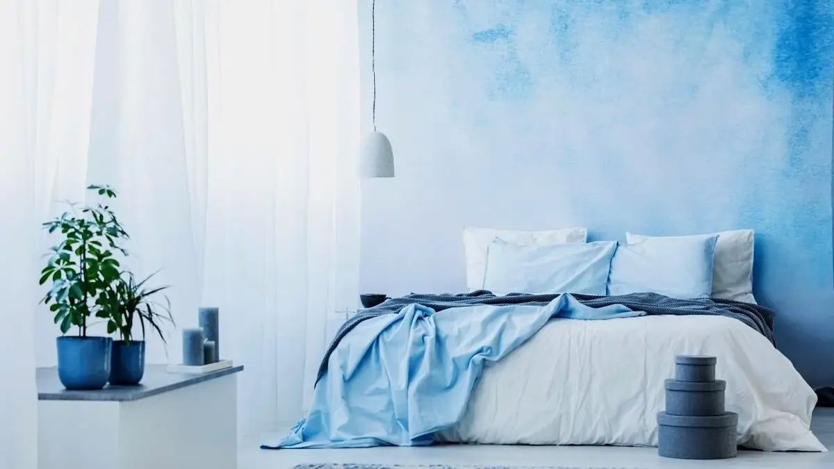 Przezroczyste białe zasłony w biało-błękitnej sypialni