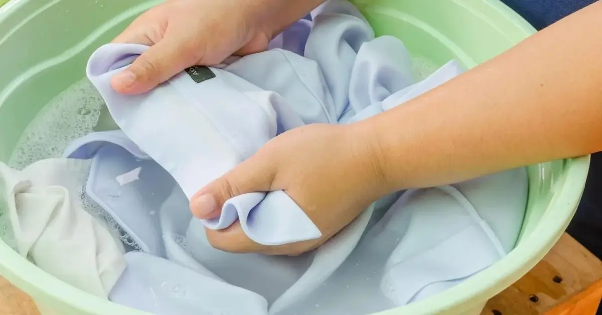 Ktoś namacza koszulę skurczoną w praniu.