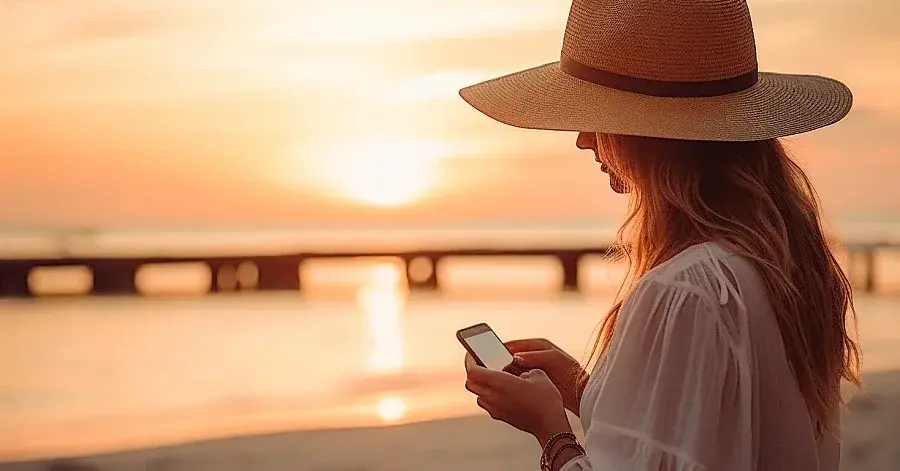 Kobieta na wakacjach nad morzem korzysta z internetu mobilnego
