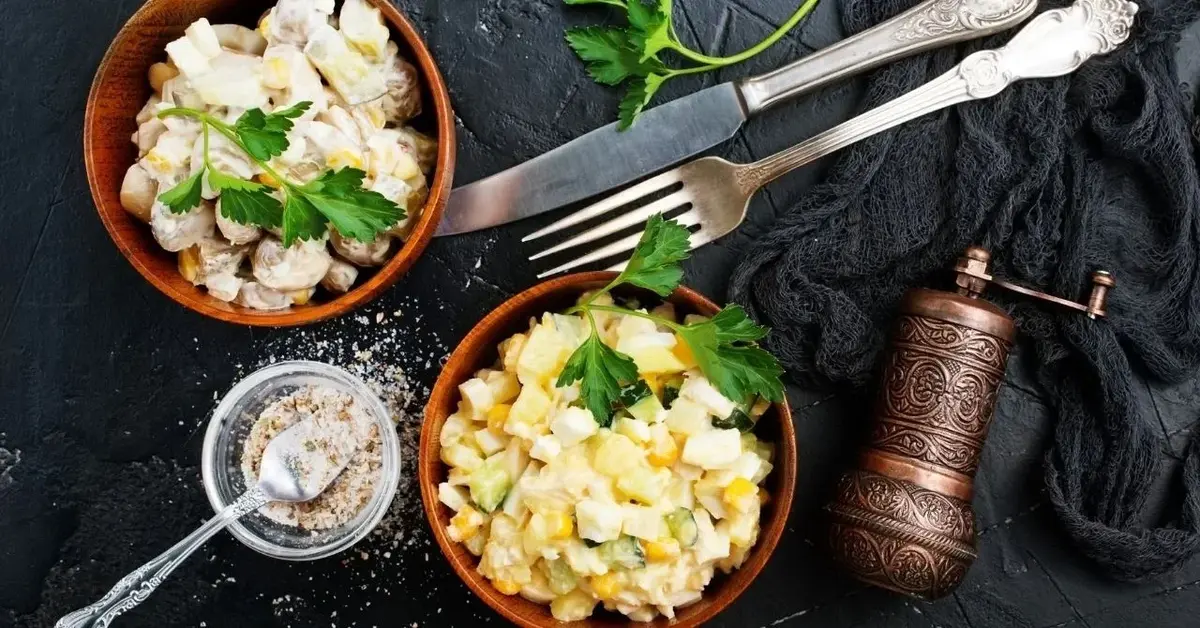 Sałatka z kukurydzą, wędzonym kurczakiem i jajkiem podana w brązowej miseczce