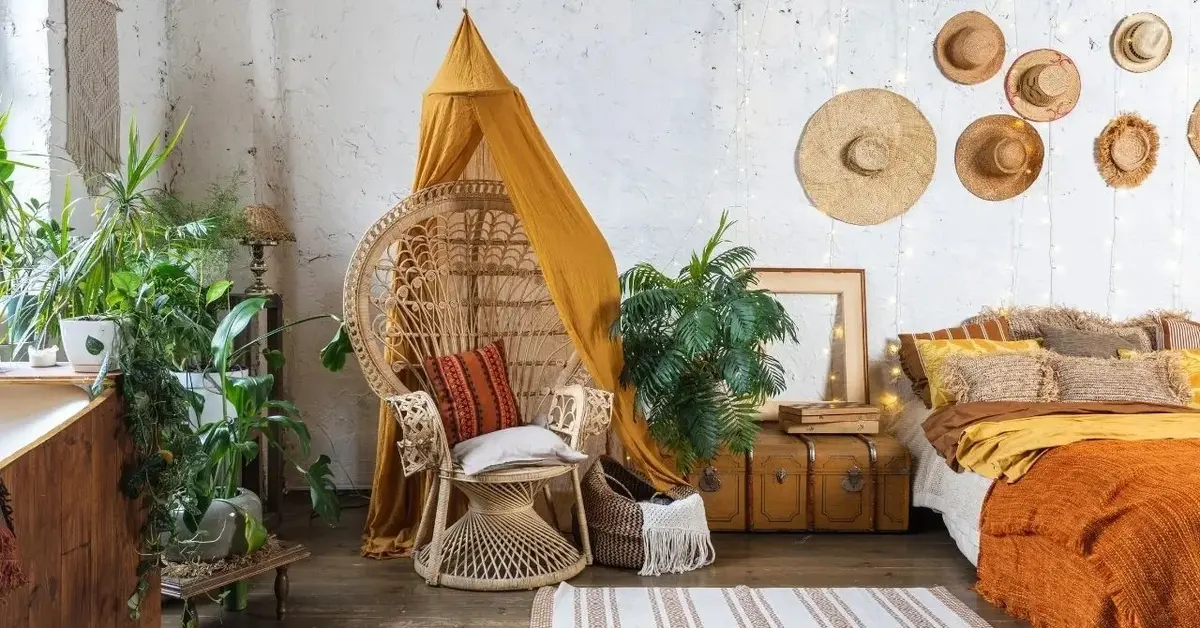 Sypialnia w stylu boho z plecionym fotelem, pomarańczowym baldachimem i dywanikiem