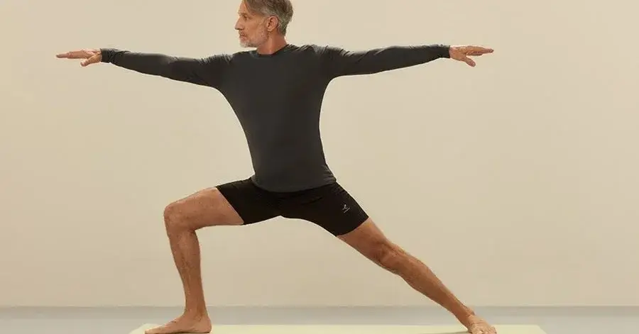 Mężczyzna w czarnym ubraniu sportowym w pozycji jogi szukając życiowego balansu