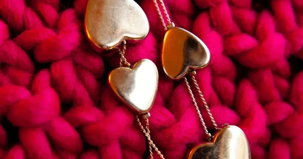 Na te czerwonej dzianiny łańcuszki ze złotymi serduszkami biżuteryjnymi