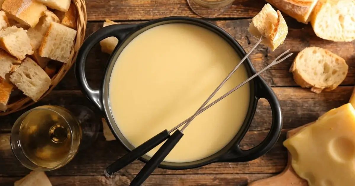 fondue zółty sos serowy  garnku obok chlebki
