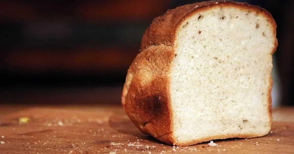 Kawałek starego chleba na desce do krojenia.