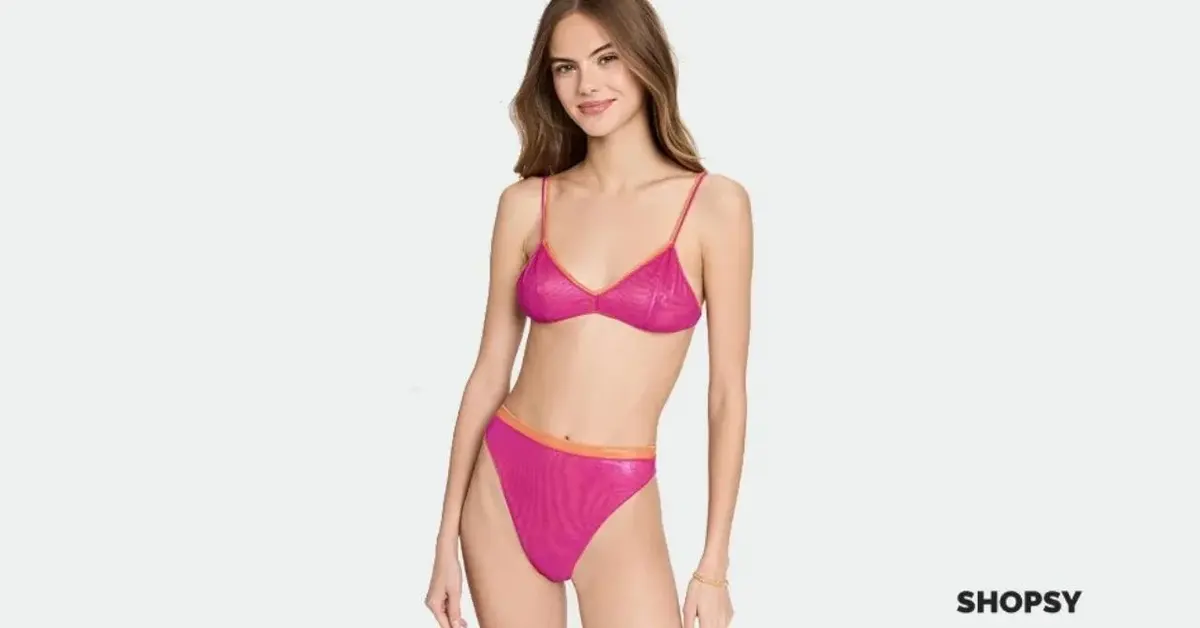 Uśmiechnięta kobieta rozpuszczone długie ciemne blond włosy w różowym bikini z wysokim stanem na białym le