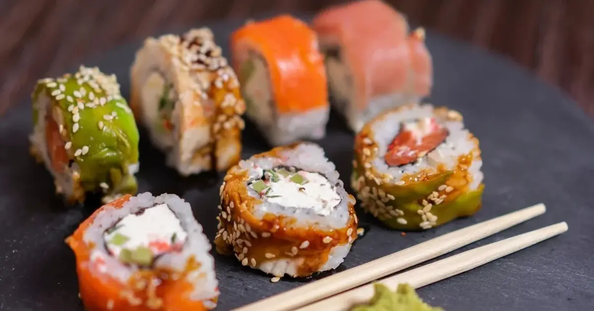kilka różnych rolek sushi z pałeczkami